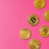 gold round coins on pink surface